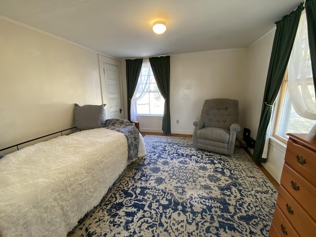 bedroom featuring ornamental molding, baseboards, and wood finished floors