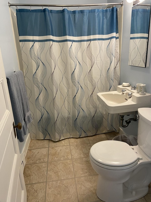 full bathroom featuring a shower with curtain, toilet, and a sink