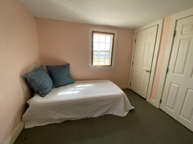 bedroom featuring baseboards and dark colored carpet