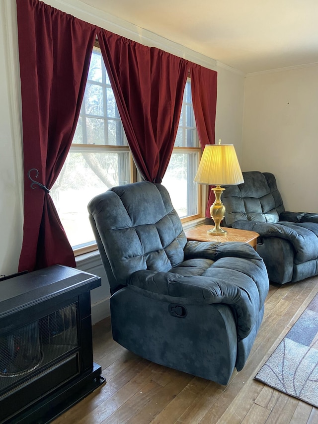 living room with a healthy amount of sunlight, ornamental molding, and hardwood / wood-style flooring