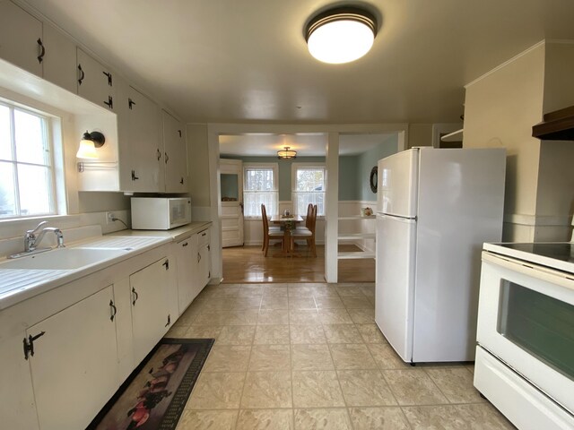 kitchen featuring a sink, white appliances, and white cabinets