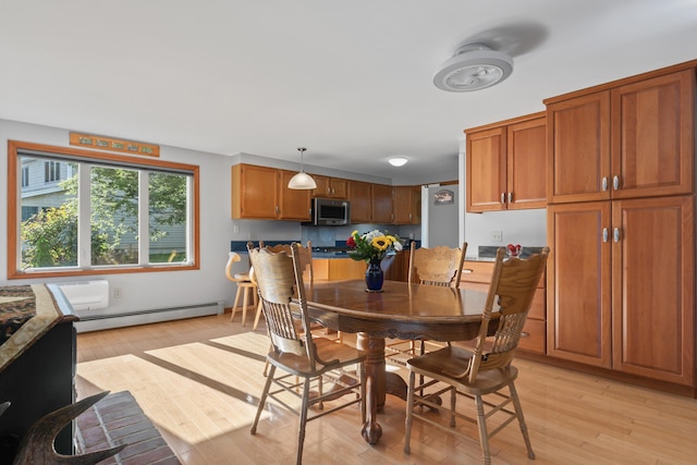 dining room with baseboard heating and light wood-style flooring