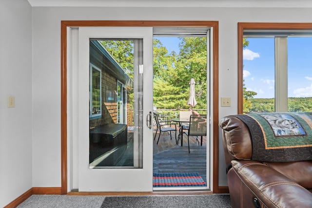 doorway featuring baseboards and carpet floors