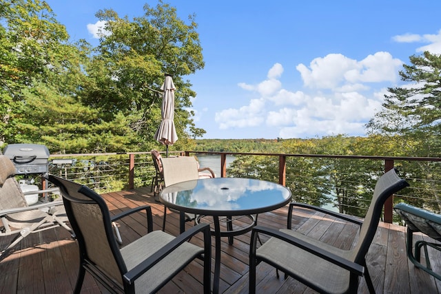 wooden terrace with outdoor dining space and grilling area