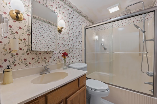 bathroom featuring wallpapered walls, a shower with shower door, vanity, and toilet