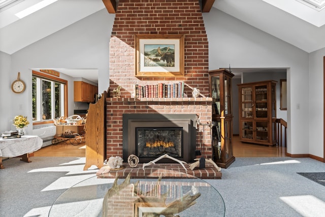 living room with a brick fireplace, a skylight, high vaulted ceiling, carpet floors, and beam ceiling