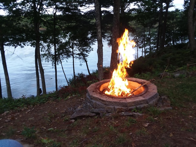 view of yard featuring an outdoor fire pit and a water view