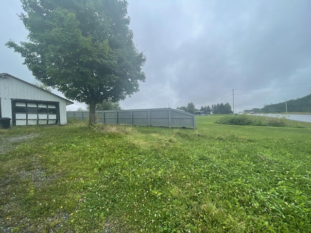 view of yard with an outbuilding and fence