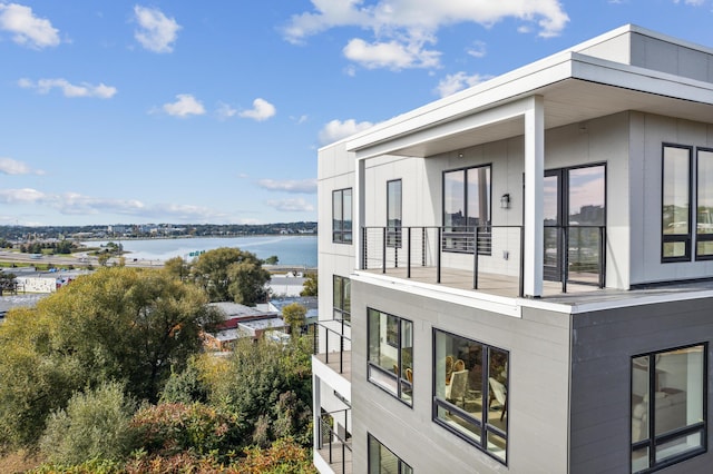 view of side of home with a water view and a balcony