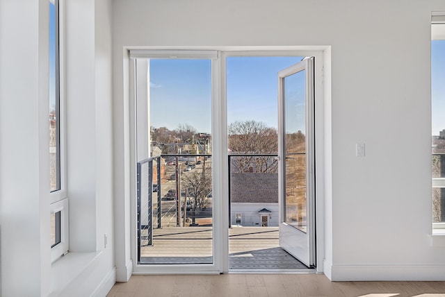 doorway featuring wood finished floors and baseboards