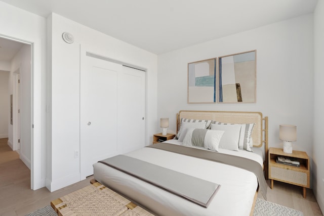 bedroom featuring a closet and light wood-style floors