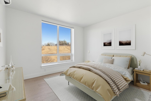 bedroom with baseboards and light wood finished floors