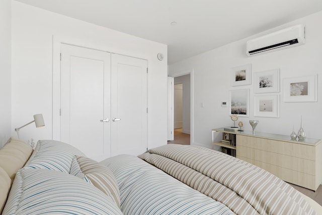 bedroom with an AC wall unit and a closet