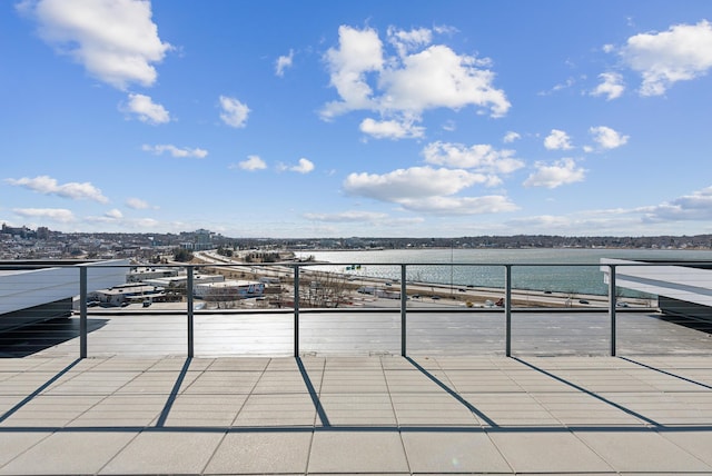 view of patio featuring a water view and a balcony