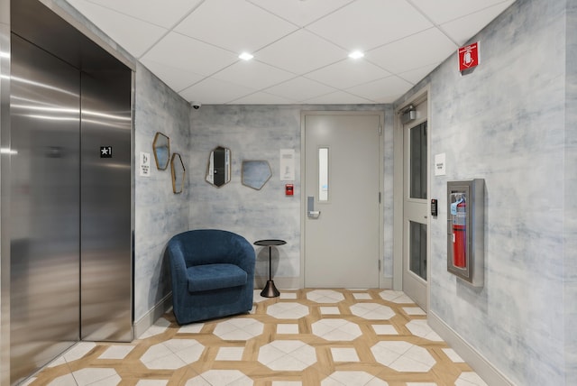 unfurnished room featuring recessed lighting, a drop ceiling, elevator, and light tile patterned flooring