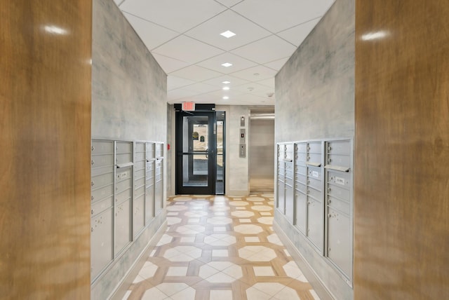 hallway with elevator, mail area, and light tile patterned floors