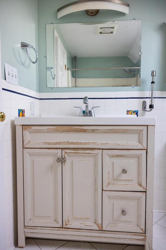 bathroom featuring tile patterned floors, wainscoting, tile walls, and vanity