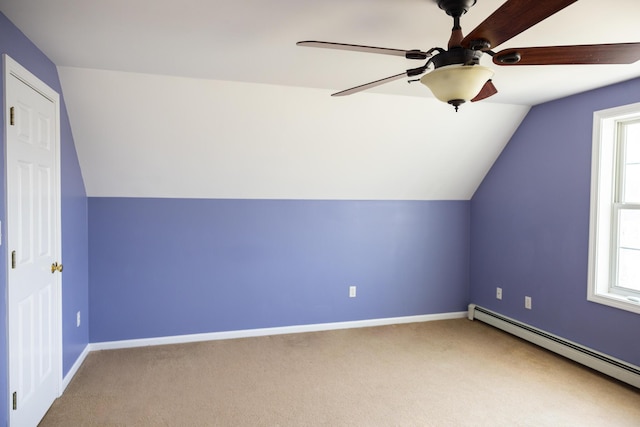 bonus room with a baseboard heating unit, plenty of natural light, a ceiling fan, and carpet floors