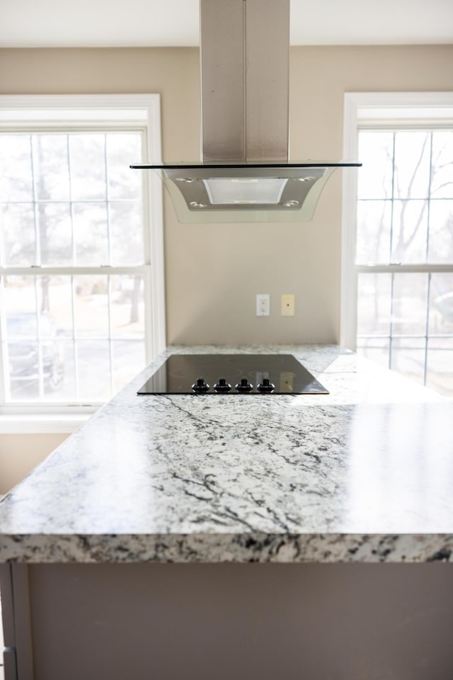 room details featuring extractor fan, black electric stovetop, light stone countertops, and island range hood