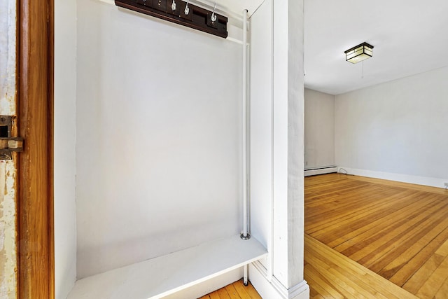 bathroom featuring hardwood / wood-style flooring, baseboards, and a baseboard radiator