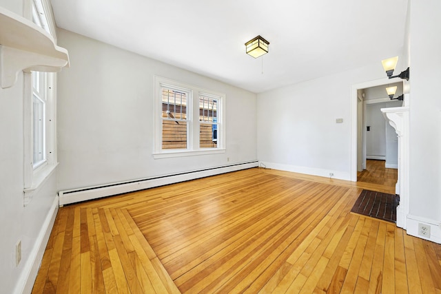 interior space with baseboards, baseboard heating, and light wood-style flooring