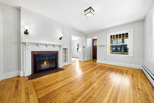 unfurnished living room featuring a fireplace, light wood-type flooring, a baseboard heating unit, and baseboards