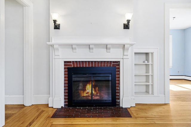 room details with a brick fireplace, baseboards, and wood finished floors