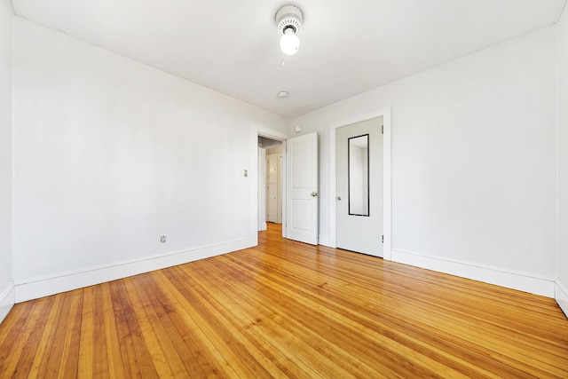 empty room featuring baseboards and light wood-style flooring