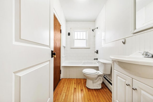 full bath featuring a baseboard heating unit, a wainscoted wall, toilet, vanity, and wood-type flooring