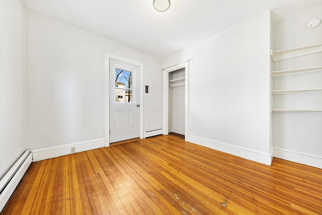 unfurnished bedroom featuring light wood-style floors, baseboards, and baseboard heating