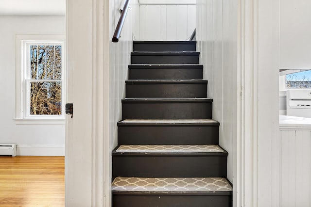 stairway featuring washer / clothes dryer, wood finished floors, and a baseboard radiator