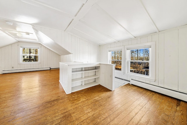 bonus room featuring light wood-type flooring, a baseboard radiator, and vaulted ceiling