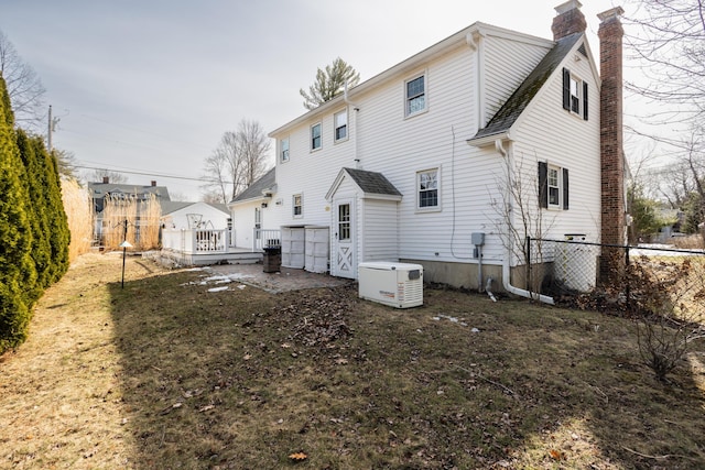 rear view of property featuring cooling unit, a chimney, a deck, and fence