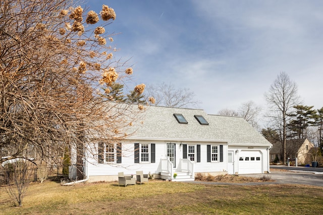 cape cod-style house featuring a front yard, an attached garage, driveway, and roof with shingles