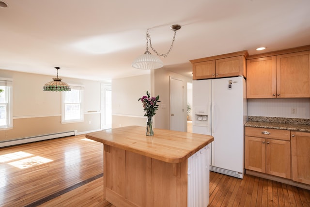 kitchen featuring hardwood / wood-style floors, butcher block countertops, white refrigerator with ice dispenser, decorative light fixtures, and a center island