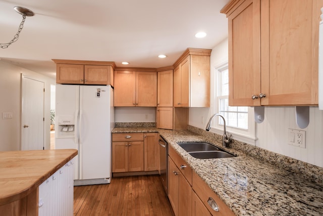 kitchen featuring dark wood finished floors, stainless steel dishwasher, white fridge with ice dispenser, wood counters, and a sink