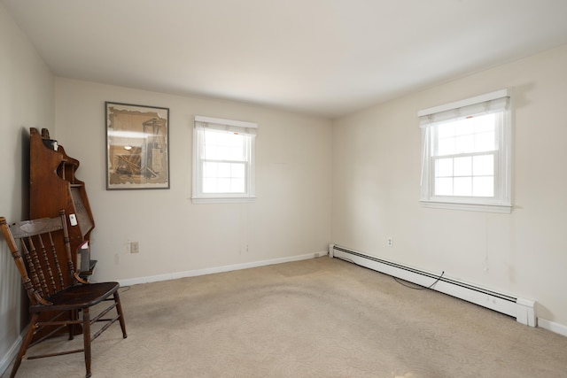 sitting room featuring light carpet, baseboard heating, and baseboards