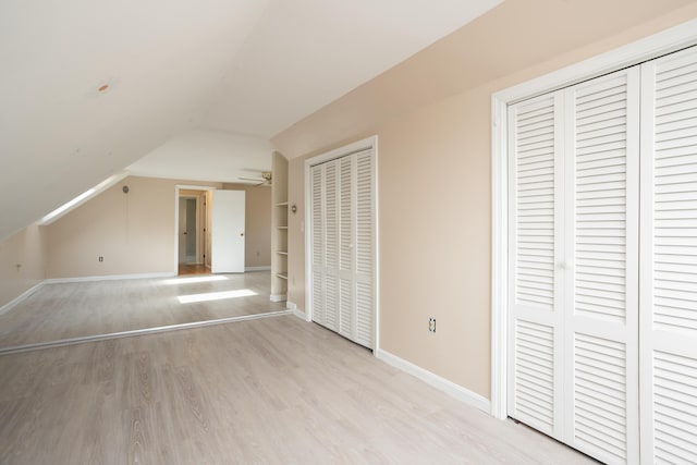 bonus room with baseboards, light wood-style floors, ceiling fan, and vaulted ceiling