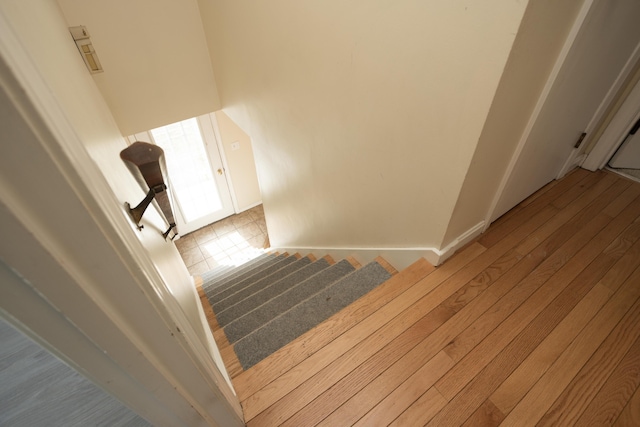 stairs with wood finished floors and baseboards