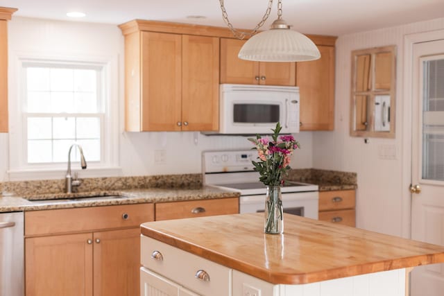 kitchen with a kitchen island, pendant lighting, butcher block counters, white appliances, and a sink