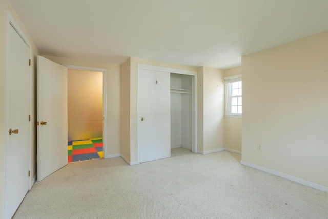 unfurnished bedroom featuring a closet, baseboards, and carpet