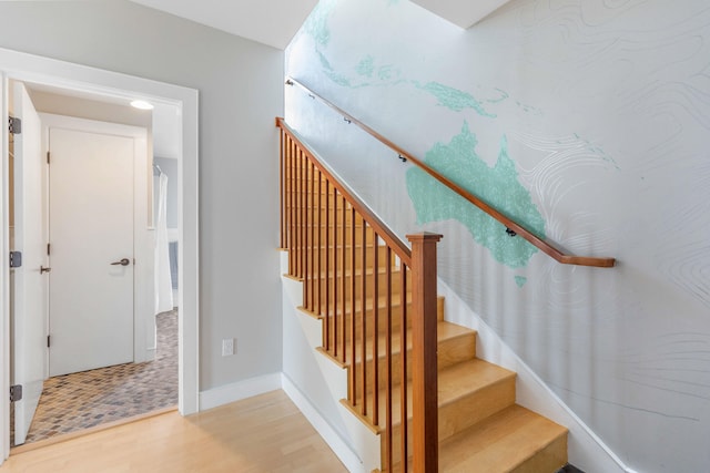 stairway featuring baseboards and wood finished floors