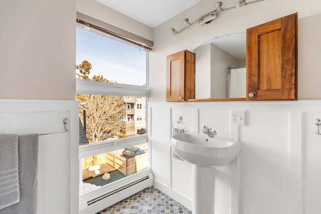 full bath featuring a sink and a baseboard radiator