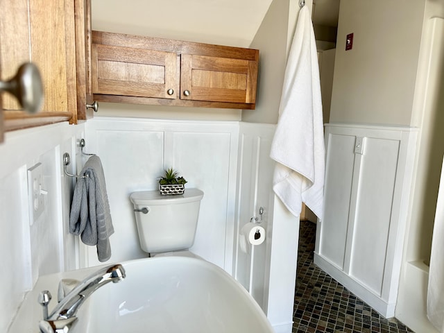 bathroom featuring a wainscoted wall and toilet