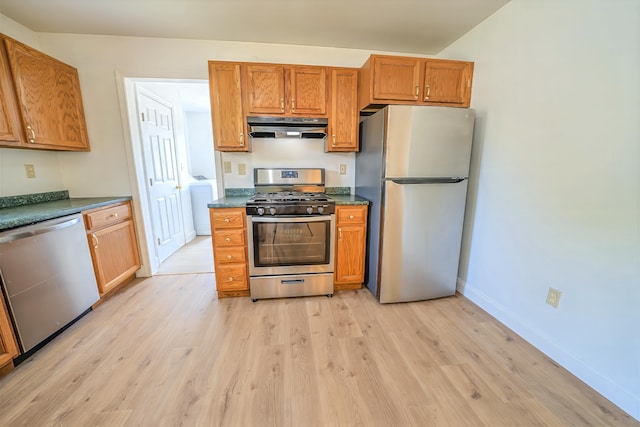 18 Oak St, Camden, ME 04843 - kitchen featuring stainless steel appliances, ventilation hood, light wood-style floors, and dark countertops
