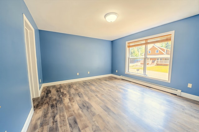 18 Oak St, Camden, ME 04843 - empty room with a baseboard heating unit and wood finished floors