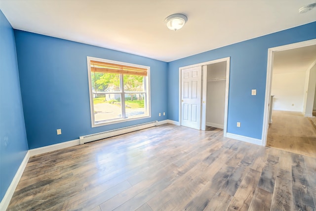 18 Oak St, Camden, ME 04843 - unfurnished bedroom with a baseboard radiator, wood finished floors, and a closet