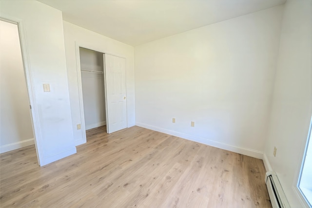 18 Oak St, Camden, ME 04843 - unfurnished bedroom with a baseboard heating unit, light wood-style flooring, and a closet
