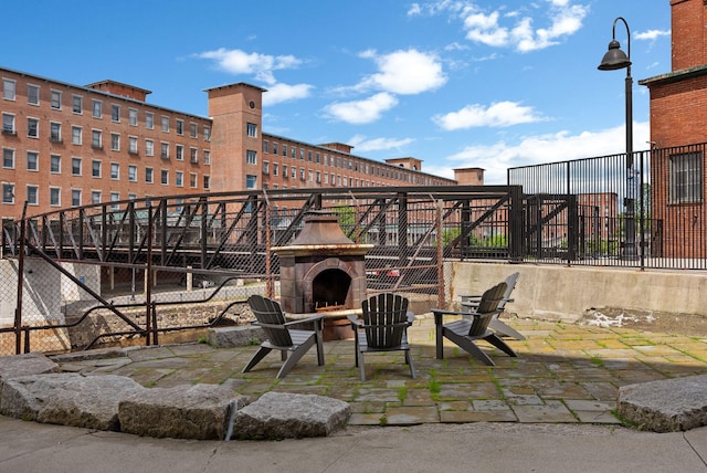 view of patio / terrace with an outdoor fireplace and fence