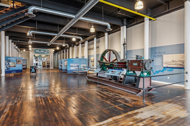 miscellaneous room featuring hardwood / wood-style flooring and a towering ceiling